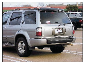 The rear of this Infiniti QX4 has several significant visual clues revealing the lift window and liftgate. The handle for the lift window is evident along the lower edge of the glass. The wiper arm sets below the glass. The mounting buttons for the windows - hydraulic lifting struts are visible. A quick glance could indicate a tailgate feature except that the handle mounted below the license plate gives away the fact that this is a liftgate design. In addition, the hinges for the liftgate are mounted along the top roofline.
