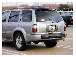 The rear of this Infiniti QX4 has several significant visual clues revealing the lift window and liftgate. The handle for the lift window is evident along the lower edge of the glass. The wiper arm sets below the glass. The mounting buttons for the windows - hydraulic lifting struts are visible. A quick glance could indicate a tailgate feature except that the handle mounted below the license plate gives away the fact that this is a liftgate design. In addition, the hinges for the liftgate are mounted along the top roofline. The rear of this Infiniti QX4 has several significant visual clues revealing the lift window and liftgate. The handle for the lift window is evident along the lower edge of the glass. The wiper arm sets below the glass. The mounting buttons for the windows - hydraulic lifting struts are visible. A quick glance could indicate a tailgate feature except that the handle mounted below the license plate gives away the fact that this is a liftgate design. In addition, the hinges for the liftgate are mounted along the top roofline.