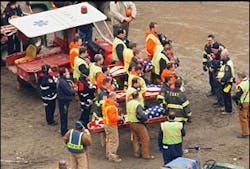 A prayer is said for three flag-draped New York firefighters just removed March 12, 2002, in New York.