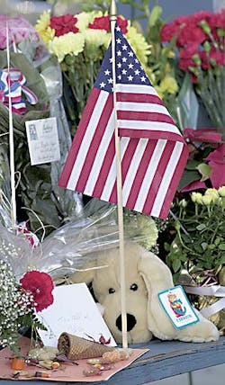 A stuffed dog, cards, notes and flags are among the items left on a park bench outside the Coos Bay Fire Station No. 1 on the corner of Anderson and South Fourth streets Tuesday.