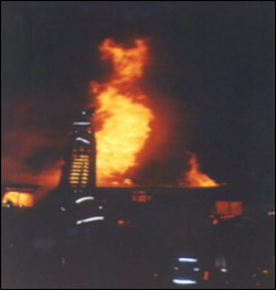 The results of a typical night time shot taken with a point and shoot camera. The built- in flash is not powerful enough to illuminate the entire scene and will just highlight the reflective stripes on the turnout gear.