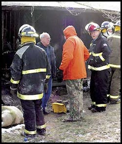 Newport Police Chief Clay Webb, center, confers with Newport Fire Chief Wayne Butler Saturday morning at the scene of a house fire which claimed the lives of a Newport couple and their three children. © 2003 NPT Newport Police Chief Clay Webb, center, confers with Newport Fire Chief Wayne Butler Saturday morning at the scene of a house fire which claimed the lives of a Newport couple and their three children. © 2003 NPT