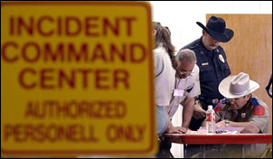 Emergency management officials work into the night along with members of the National Forest Service at a command center at the Hemphill, Texas firehouse, Saturday, Feb. 1, 2003