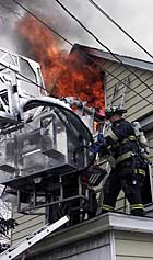 HEROES: Volunteer firemen T. J. Fernandez and Ryan Cassidy followed the black cloud to a Roosevelt home where they rescued 4-year-old twins from the blaze.