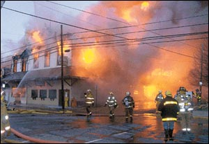 Firefighters battle flames Sunday at the Knotty Pine Restaurant just before the building's facade toppled onto Elm Street, Tionesta. At least three firefighters were injured throughout the evening.