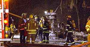 A gasoline tanker truck overturned and exploded early today on West Ridge Road near the Veteran&rsquo;s Bridge, sparking a five-alarm fire that killed one person, sent nine people to hospitals and mobilized every fire department in the county. Firefighters are seen early today near the foam-covered axles of the burned-out truck.