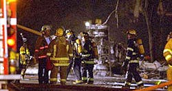 A gasoline tanker truck overturned and exploded early today on West Ridge Road near the Veteran’s Bridge, sparking a five-alarm fire that killed one person, sent nine people to hospitals and mobilized every fire department in the county. Firefighters are seen early today near the foam-covered axles of the burned-out truck. A gasoline tanker truck overturned and exploded early today on West Ridge Road near the Veteran’s Bridge, sparking a five-alarm fire that killed one person, sent nine people to hospitals and mobilized every fire department in the county. Firefighters are seen early today near the foam-covered axles of the burned-out truck.