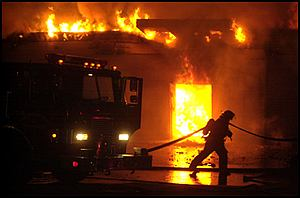 A Memphis firefighter battles a blaze Sunday night at the Family Dollar store at 3732 N. Watkins in Frayser. Firefighters were trapped for a time in the building, officials said.