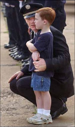 Memphis firefighter Tim Bottom comforts his son Ethan as the funeral procession passes in front of Station 27. Memphis firefighter Tim Bottom comforts his son Ethan as the funeral procession passes in front of Station 27.