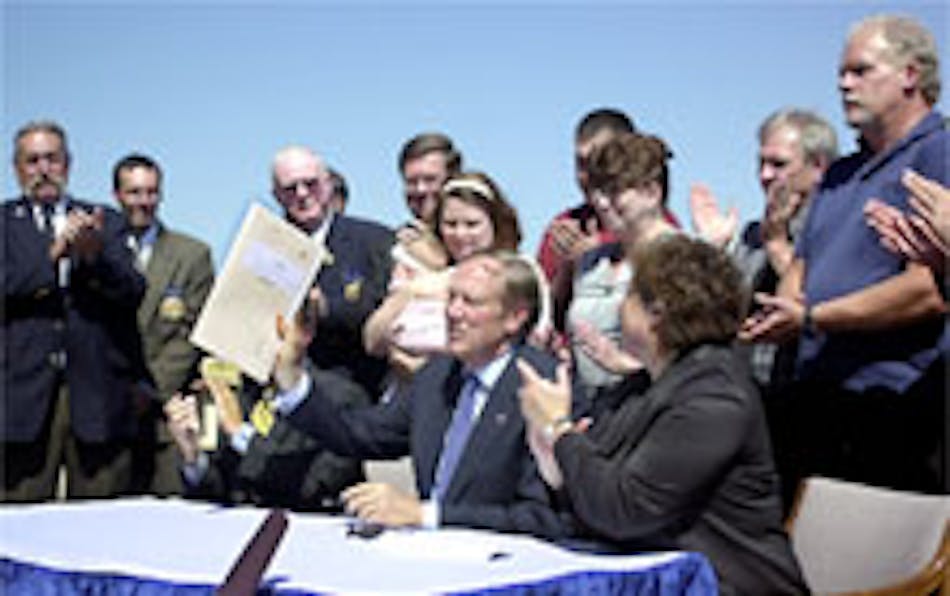 Governor George Pataki holds up the signed copy of Bradley&apos;s Law at the New York State office building Thursday in Utica. Bradley&apos;s Law is named for Bradley Golden, a Lairdsville volunteer firefighter trainee who was killed in a live fire exercise, Sept. 25, 2001. The law prohibits the use of live firefighters as victims during live burn exercises.