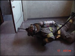 A firefighter is using his two tools to maintain contact with his entry window and close the bedroom door. His search area is greatly increased.