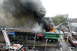 Fire crews battle a four-alarm blaze in Sunnyside, Queens, yesterday. The inferno gutted several businesses. Fire crews battle a four-alarm blaze in Sunnyside, Queens, yesterday. The inferno gutted several businesses.