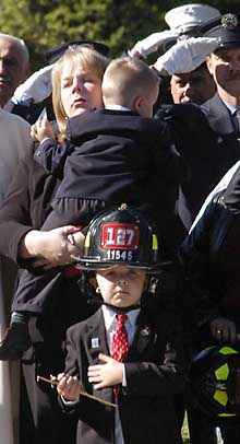 James O'Shea's son Jacob stands by his mother and brother as the coffin bearing his father begins its final journey.
