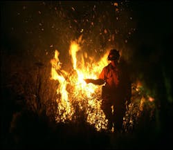 A firefighter sets a controlled fire to a hillside to burn off brush in an attempt to keep a wildfire from spreading in Lakeside, Calif. Monday night, Oct 27, 2003. A firefighter sets a controlled fire to a hillside to burn off brush in an attempt to keep a wildfire from spreading in Lakeside, Calif. Monday night, Oct 27, 2003.