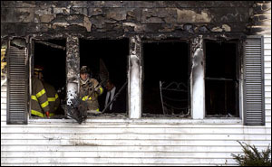 A firefighter with the Canton Fire Department uses a shovel to clear debris, while investigators search for clues to the cause of a fatal fire, Tuesday, Dec. 23, 2003, in Canton, Ohio. An early morning fire engulfed a house Tuesday, killing two adults and four children, the coroner's office said. A seventh person, a woman, was flown by helicopter to an Akron hospital in critical condition with burns, said Rick Walters, an investigator with the Stark County Coroner's Office.