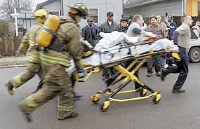 The second of two boys taken from a burning home on East Highland Avenue in Muncie is rushed to an ambulance Monday.