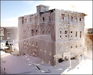 Firefighters in Bangor, Maine, Friday, Jan. 16, 2004, use a snorkel truck to put water on a stubborn blaze in an historic building. The building, which housed a Masonic lodge and three businesses was reported on fire Thursday night. Sub-zero temperatures and wind chill created ice and snow several feet deep at the base of the building.