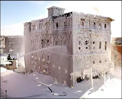 Firefighters in Bangor, Maine, Friday, Jan. 16, 2004, use a snorkel truck to put water on a stubborn blaze in an historic building. The building, which housed a Masonic lodge and three businesses was reported on fire Thursday night. Sub-zero temperatures and wind chill created ice and snow several feet deep at the base of the building.