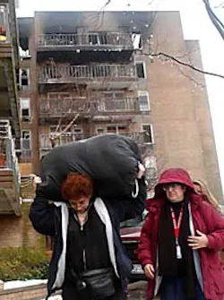 Brooklyn residents retrieve their belongings yesterday in the wake of a Saturday-morning blaze that killed two people.