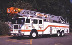 Rear-mount aerial ladder units offer large body compartments without sacrificing fire pump, water tank and hosebed areas that are used on quint apparatus. Note the short ladder overhang in front of the cab on this Seagrave rear-mount ladder company apparatus operated by the Tenafly, NJ, Fire Department.