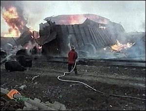 An Iranian firefighter sprays a destroyed train after it exploded outside the Iranian town of Neyshapur, Iran, in this image made from television Wednesday, Feb. 18, 2004. More than 200 people were killed and five villages were devastated according to the official Islamic Republic News Agency.