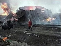 An Iranian firefighter sprays a destroyed train after it exploded outside the Iranian town of Neyshapur, Iran, in this image made from television Wednesday, Feb. 18, 2004. More than 200 people were killed and five villages were devastated according to the official Islamic Republic News Agency.