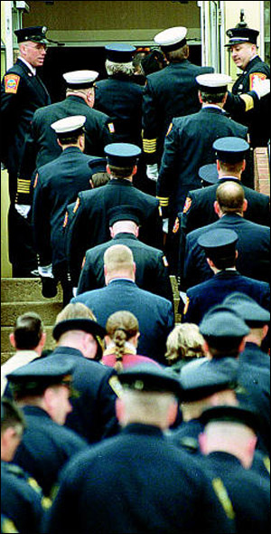 Laconia Firefighters Steve Hanser, left, and Mark Beauchemin hold the doors for the hundreds of fellow firemen, friends and family who came to mourn the loss of Firefighter Mark Miller during calling hours at the Wilkinson-Beane Funeral Home in Laconia Tuesday.
