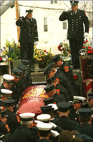 Laconia firefighters salute as their comrades place Miller&rsquo;s flag-draped casket on Engine 1 for his last ride.