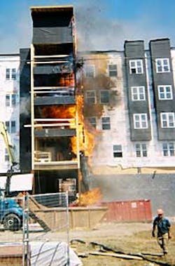 In this photo, taken within minutes after the fire began, flames move through a debris chute, making their way from a trash dumpster to a building under construction. In this photo, taken within minutes after the fire began, flames move through a debris chute, making their way from a trash dumpster to a building under construction.