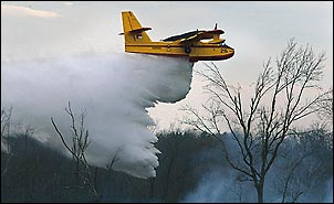 North Carolina Forest Service's CL 215 Super Scooper plane drops 1,200 gallions of water at a time. Several drops were needed to help control the 75-acre woods fire near Jones Lester Road Wednesday.