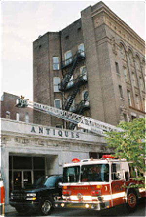 Members of the second due Truck Company assist command in sizing-up the involved structure by observing the rear of the structure and the involved exposures on Side C.