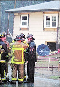 Walpole firefighters stand outside a house on Rockwood Street where four firefighters were injured in a gas explosion Tuesday. Walpole firefighters stand outside a house on Rockwood Street where four firefighters were injured in a gas explosion Tuesday.