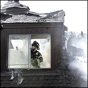 A Norwood firefighter battles a two-alarm blaze inside a Normandy Drive apartment complex yesterday.