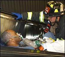 A firefighter gives oxygen to a passenger injured when an Amtrak maintenance train crashed into an LIRR train about to enter Penn Station yesterday.