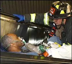 A firefighter gives oxygen to a passenger injured when an Amtrak maintenance train crashed into an LIRR train about to enter Penn Station yesterday.