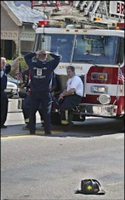 Firefighters stand by as the helmet belonging to Irwin ``Buzz'' Gross mark evidence at the scene. Firefighters stand by as the helmet belonging to Irwin ``Buzz'' Gross mark evidence at the scene.