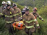 Firefighters carry an injured woman up the side of the gorge at Plotter Kill Nature Preserve