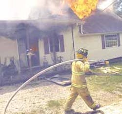 With a dripping hose signaling the end of the water supply, a firefighter heads away as flames consume the home of Rick and Bonnie Spinks earlier this month
