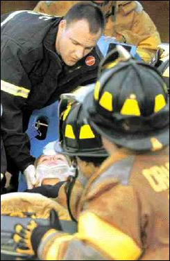 Cranston Heights firefighter Jim Grieco lifts firefighter Kristen Merring during a recent drill at the Kirkwood Highway firehouse. The hundreds of hours of training it takes to become a certified firefighter have contributed to the decline in ranks.