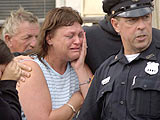 Mary Rodriguez, center, cries as she watches her mother's apartment go up in flames on Grove Street in Mechanicville on Wednesday, Aug. 4, 2004.