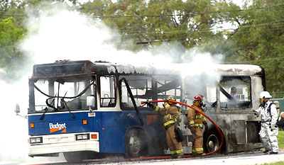 Firefighters extinguish a fire on a Budget Rent A Car shuttle bus near Fort Lauderdale-Hollywood International Airport