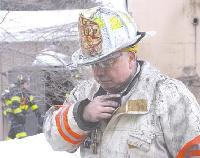 Deputy Leominster Fire Chief Ronald Pierce speaks on his radio as fire crews extinguish a fire at Modern Dispersions Inc.