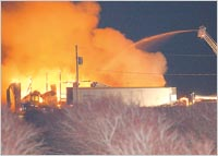 Firefighters from several area fire departments help in extinquishing a barn fire at Krupka's Blueberry Plantation