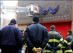 Area firefighters watch, Monday, Jan. 24, 2005, as colleagues hang bunting on their Engine 26 Ladder 27 firehouse in memory of firefighter John Bellew of Ladder 27, who was killed with another firefighter while battling a Bronx blaze Sunday that injured serveral other firefighters. With the death of a third firefighter in Brooklyn, Sunday was the deadliest day the New York City Fire Dept. has seen since the Sept. 11, 2001, attack on the World Trade Center