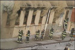 Firefighters work to ventilate second-floor windows while operating on the roof of a portion of the mattress factory. Heavy smoke was being fanned by high winds. Firefighters work to ventilate second-floor windows while operating on the roof of a portion of the mattress factory. Heavy smoke was being fanned by high winds.