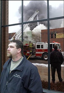 Ron Schweitzer watches firefighters work to put out a fire in Dover, Ohio with the scene reflected behind him, Thursday, Feb. 3, 2005. The fire damaged an entire city block. Ron Schweitzer watches firefighters work to put out a fire in Dover, Ohio with the scene reflected behind him, Thursday, Feb. 3, 2005. The fire damaged an entire city block.