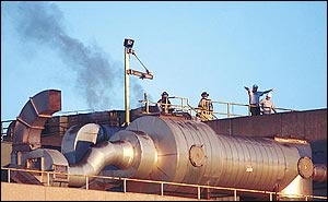 Members of the Jonesboro Fire Department and plant employees stand on the roof of the building while firefighters attempt to make their way to a fire inside the Post Cereal-Kraft Foods plant late Monday, Feb. 14, 2005, in Jonesboro, Ark. Firefighters said the blaze was contained to a single boiler room on the third floor of the structure.