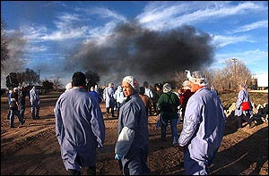 Boca Burger employees wait in an evacuation area near their plant as members of the Hobbs Fire Department battle a blaze at the plant, Monday, Feb. 14, 2005, in Hobbs, N.M.