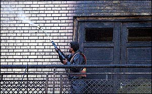 An Iranian worker, washes the wall of Arg mosque, where a fire broke out on Monday.