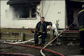 Mike Cook, an Kokomo firefighter, takes a few minutes after searching for people trapped in a burning home in Kokomo, Ind., Sunday morning, Feb. 20, 2005. A woman died along with three of her children.
